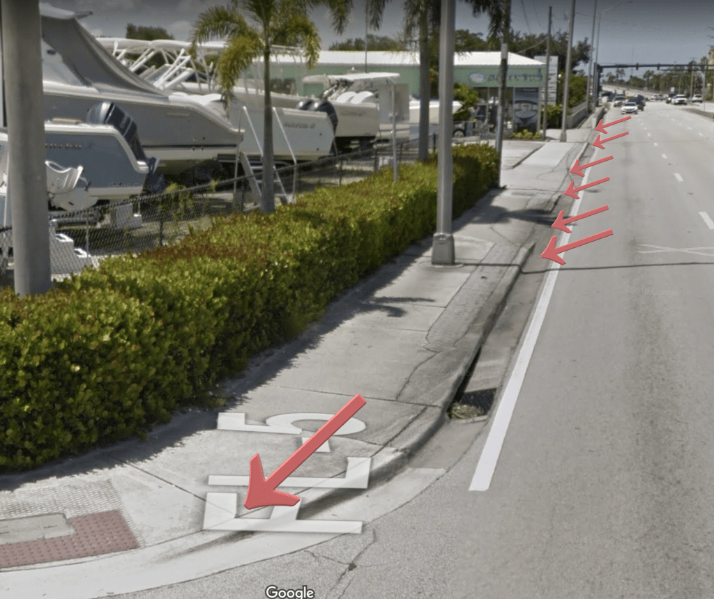 Picture of US-1 in Stuart showing driveway sidewalk crossing where driveway aprons cause cross-slope sections that could push people on bikes/trikes/scooting/walking out into fast traffic.